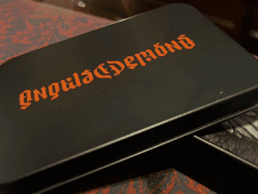 Boîte noire avec texte orange 'Angels & Demons' pour magie.